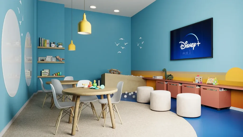 Ambiente escolar colorido com mesas infantis e parede azul com adesivos